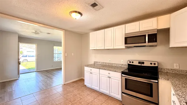 a kitchen with stainless steel appliances granite countertop a stove and a microwave