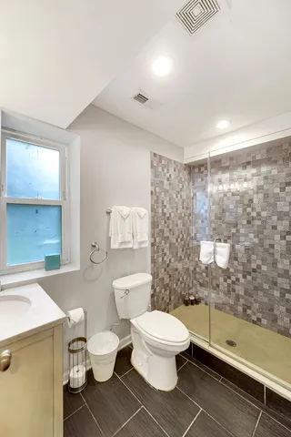 a white toilet sitting next to a bathroom sink