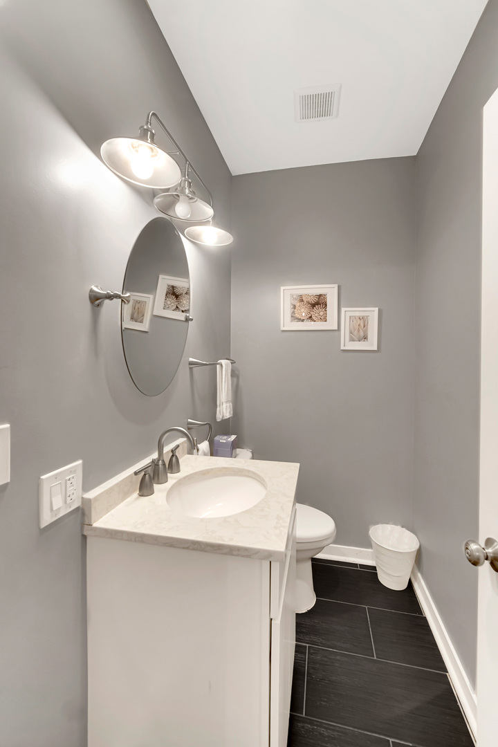 2123 West Adams Street Chicago, IL 60612 - Photo 9 of 29 a bathroom with a sink a toilet and a mirror