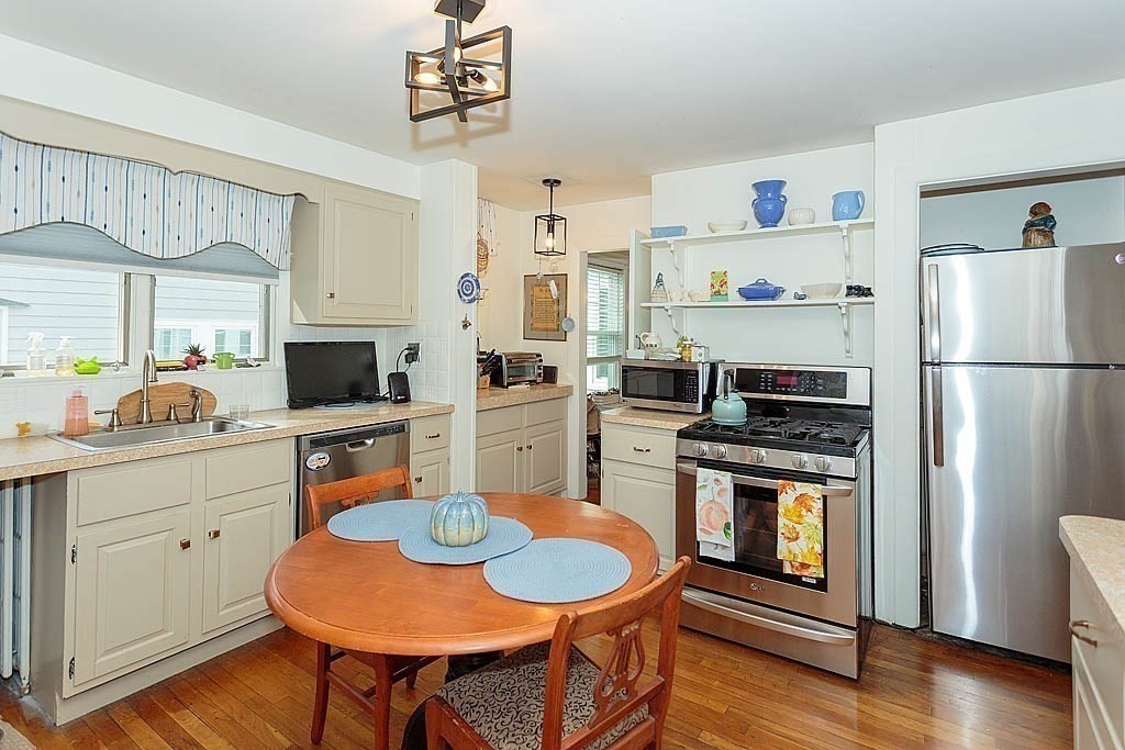 15 Fairfax Road Milton, MA 02186 - Photo 36 of 37 a kitchen with stainless steel appliances a dining table a stove a refrigerator and cabinets