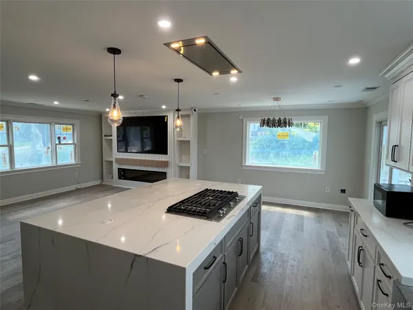 a kitchen with stainless steel appliances granite countertop a stove top oven a sink dishwasher and a refrigerator