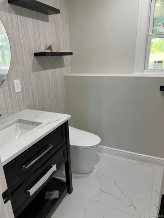 a bathroom with a toilet a sink and mirror