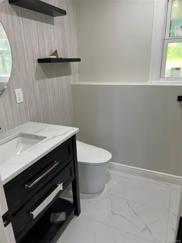 a bathroom with a toilet a sink and mirror