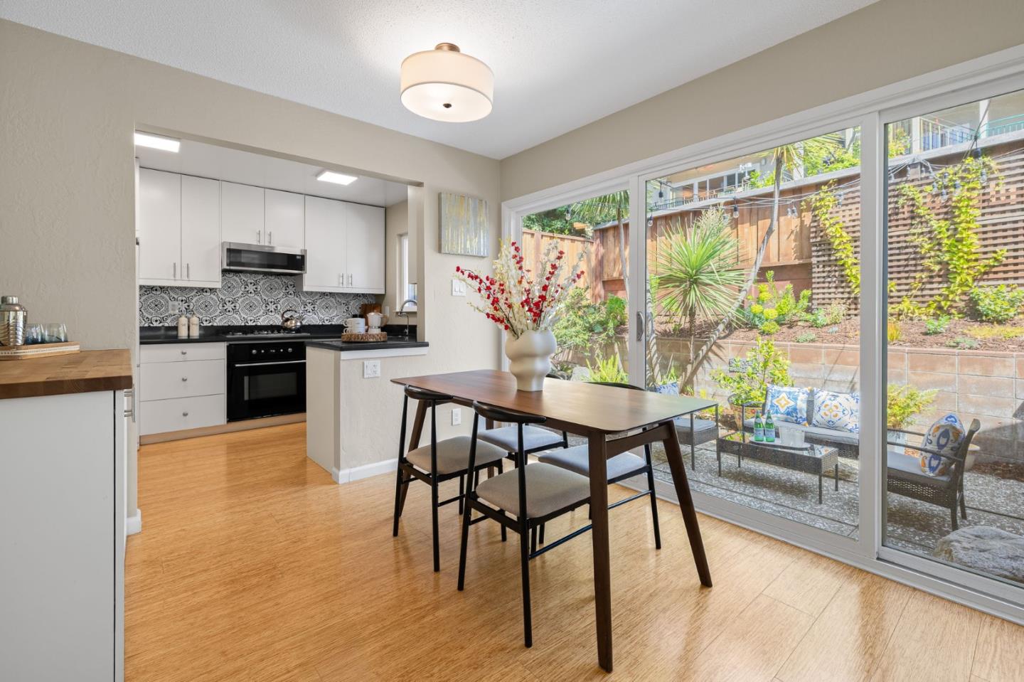 1337 Henry Street, Unit E Berkeley, CA 94709 - Photo 9 of 33 a kitchen with stainless steel appliances granite countertop a stove top oven a sink a dining table and chairs with wooden floor