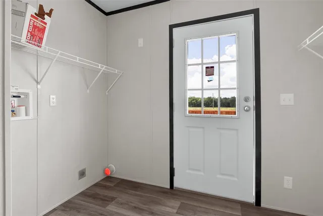 a view of an empty room with wooden floor and closet