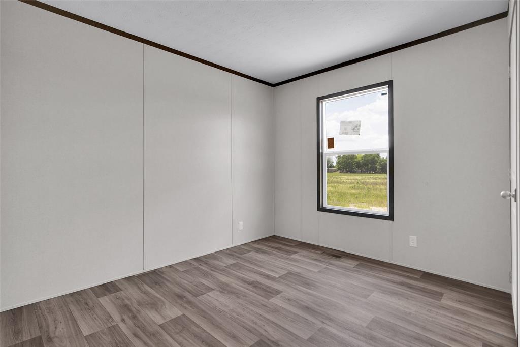 1203 Old Ida Road Sherman, TX 75090 - Photo 16 of 20 a view of an empty room with wooden floor and a window