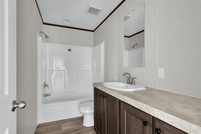 a bathroom with a granite countertop sink a toilet and shower