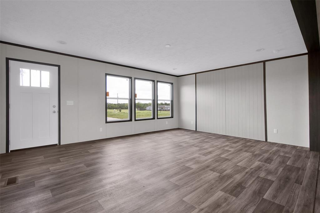 1203 Old Ida Road Sherman, TX 75090 - Photo 7 of 20 an empty room with wooden floor and windows