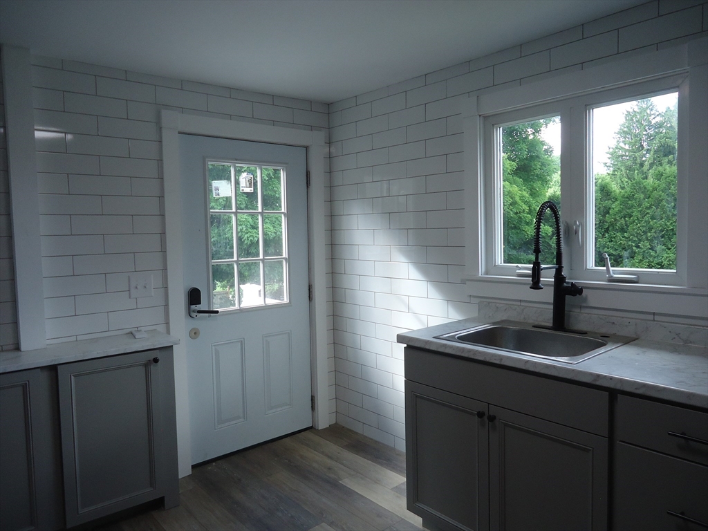 361 River Road Hudson, MA 01749 - Photo 19 of 37 a kitchen with a sink and wooden cabinets