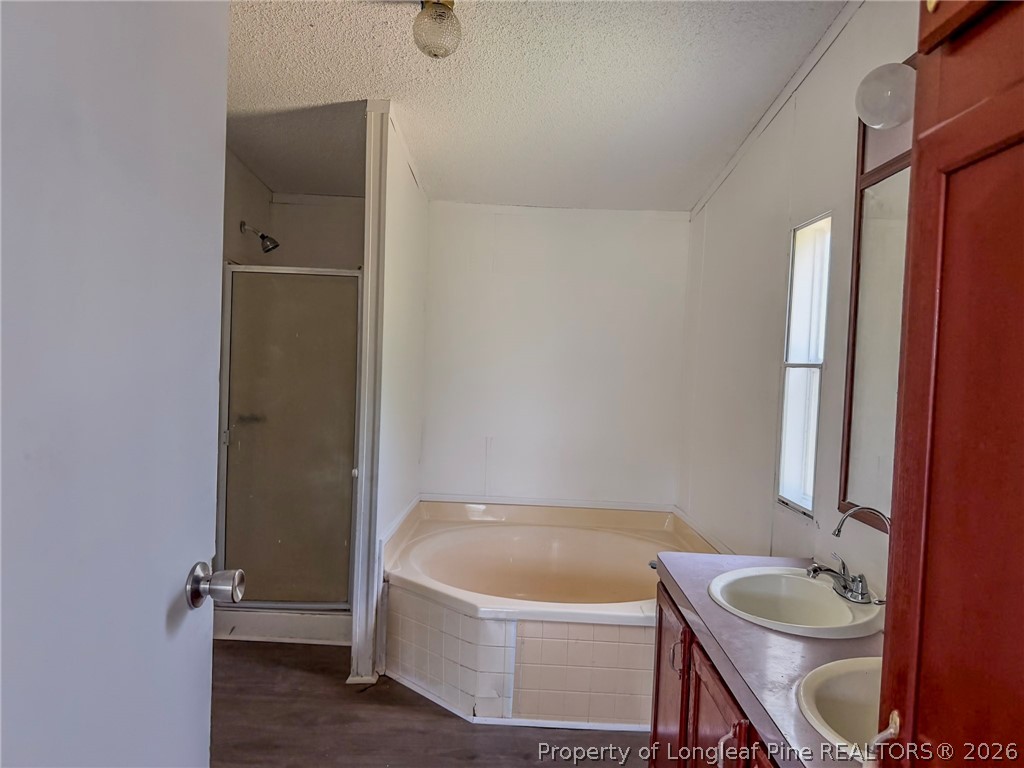 898 Brisson Road St. Pauls, NC 28384 - Photo 3 of 18 a bathroom with a tub a sink and wooden floor