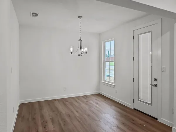 a view of empty room with wooden floor and window
