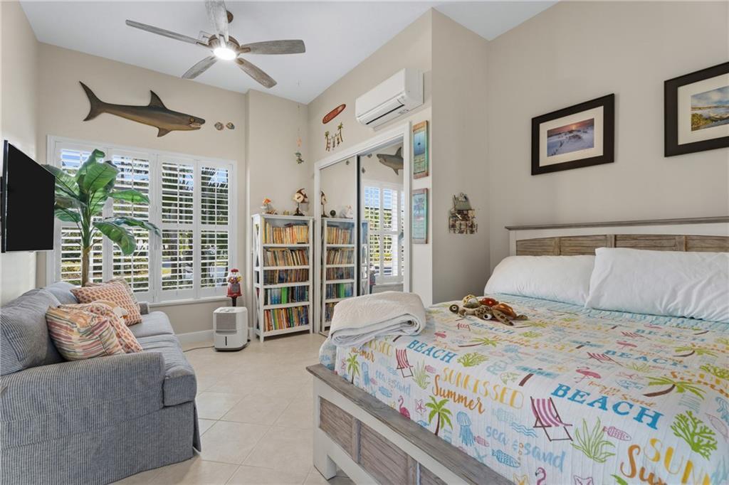 1344 Riverside Lane Vero Beach, FL 32963 - Photo 24 of 36 a bedroom with a large bed couch and a large window