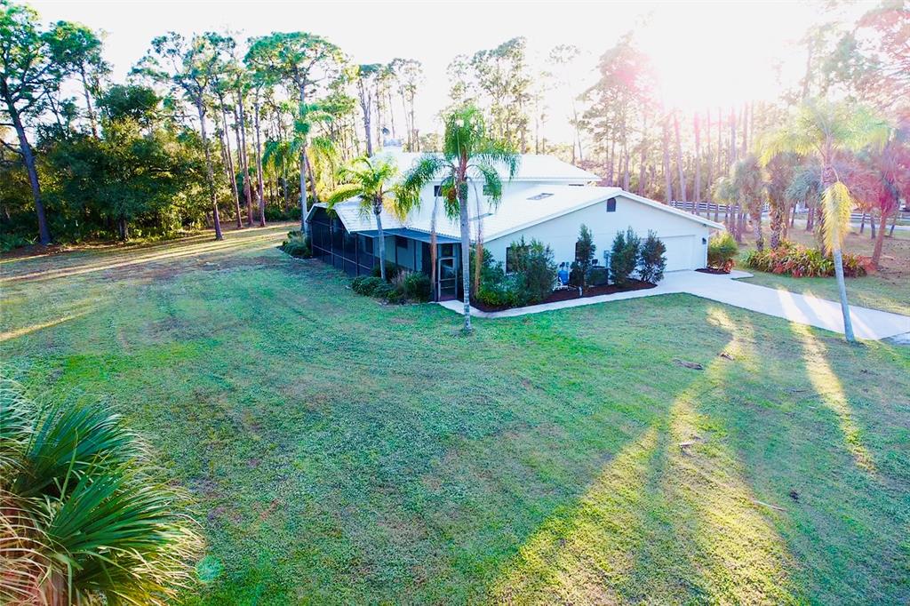 6068 Tidwell Street North Port, FL 34291 - Photo 18 of 92 a view of a house next to a big yard and large trees