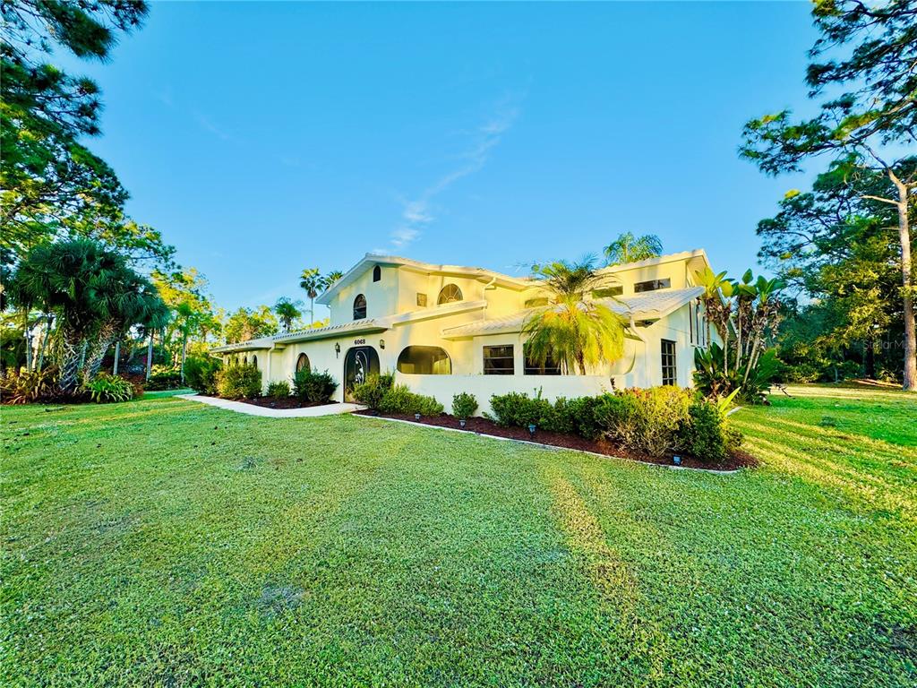 6068 Tidwell Street North Port, FL 34291 - Photo 2 of 92 a front view of a house with garden and trees