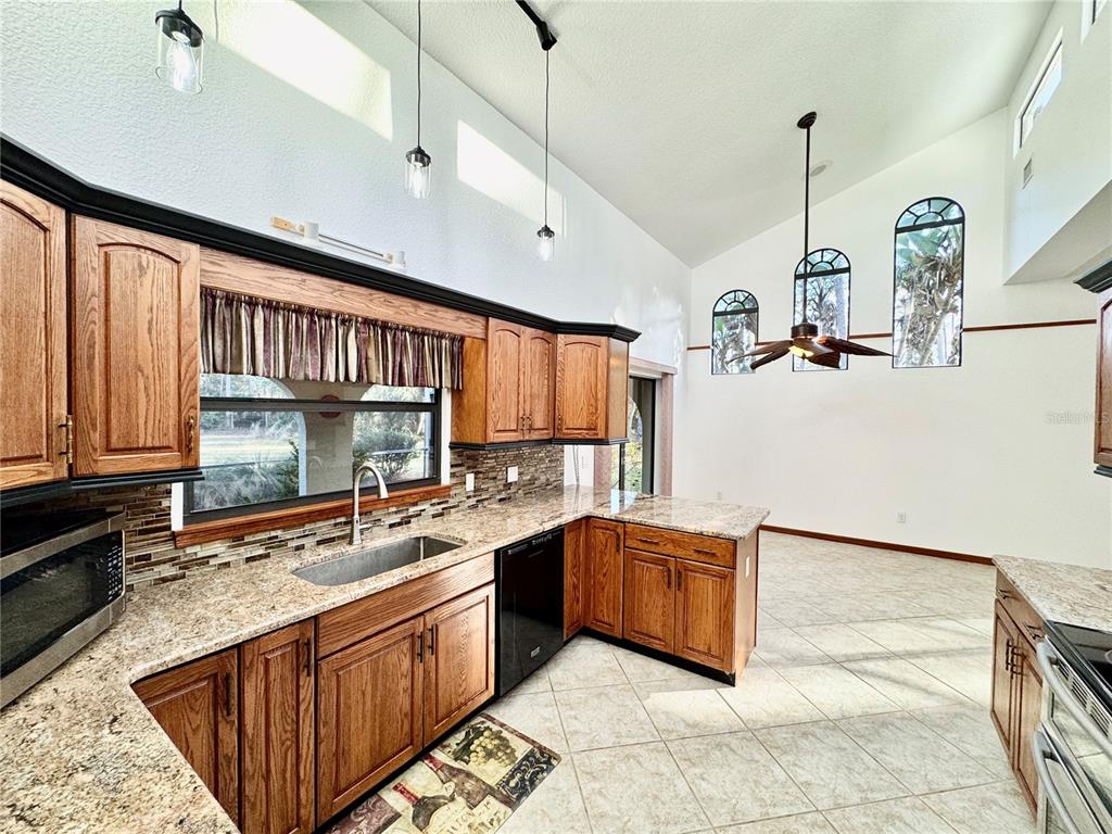 6068 Tidwell Street North Port, FL 34291 - Photo 33 of 92 a large kitchen with kitchen island a large counter space a sink and appliances