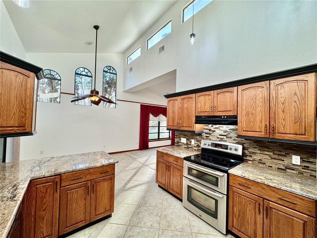 6068 Tidwell Street North Port, FL 34291 - Photo 34 of 92 a kitchen with stainless steel appliances granite countertop a stove a sink and a refrigerator