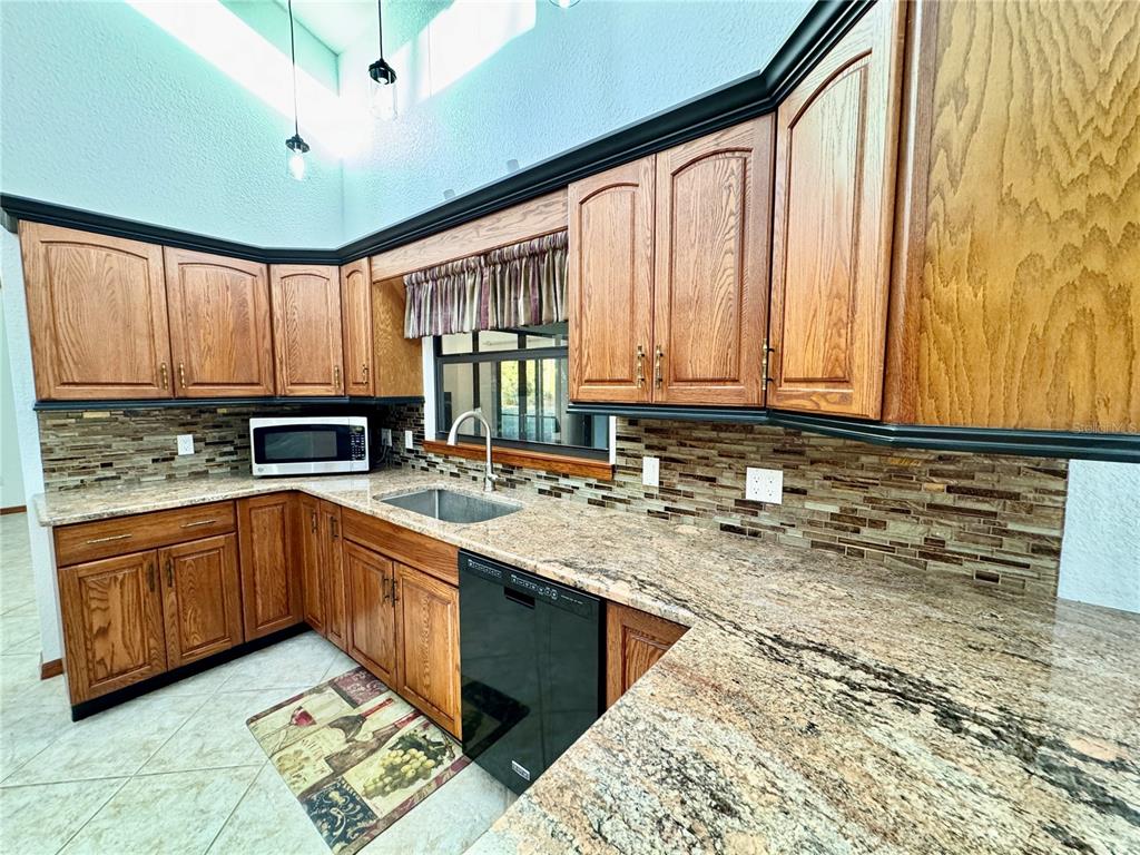 6068 Tidwell Street North Port, FL 34291 - Photo 35 of 92 a kitchen with stainless steel appliances granite countertop a sink stove and cabinets