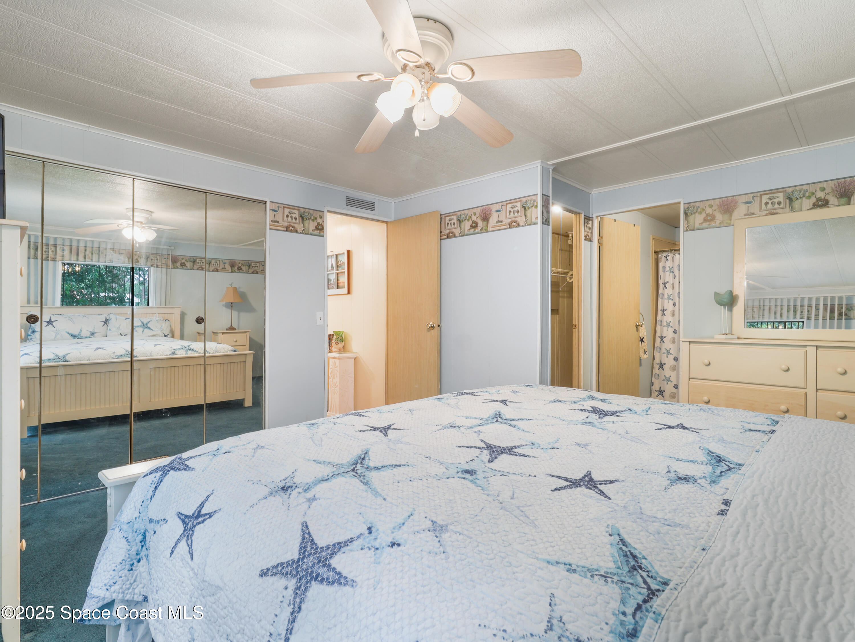 585 Canaveral Groves Boulevard Cocoa, FL 32926 - Photo 24 of 49 a spacious bedroom with a bed and a large mirror