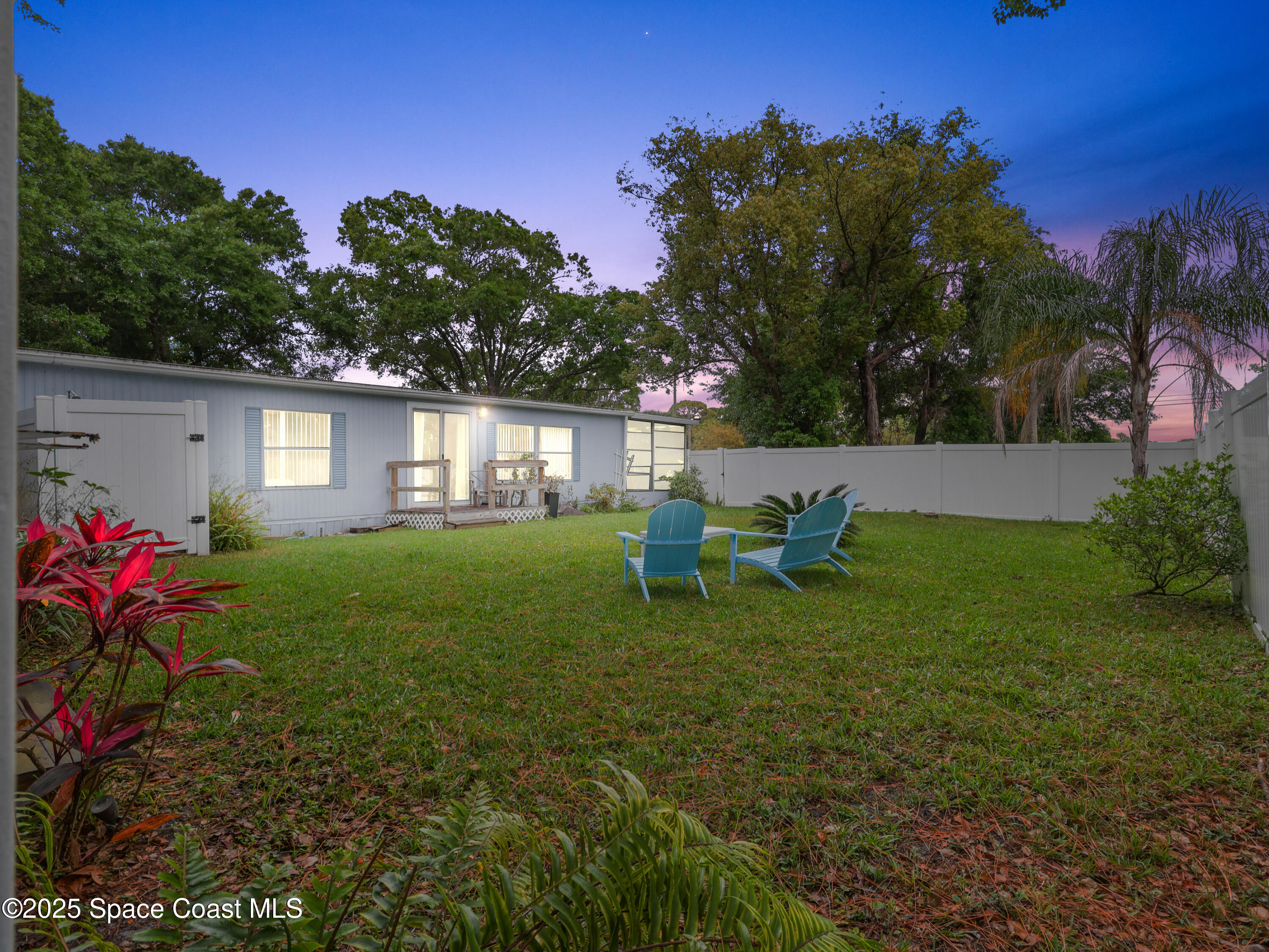585 Canaveral Groves Boulevard Cocoa, FL 32926 - Photo 27 of 49 a garden with a bench in front of the house