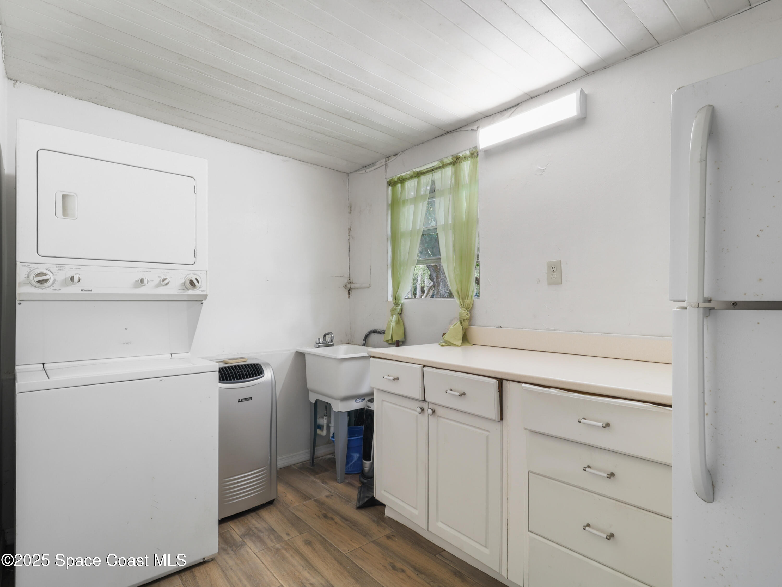 585 Canaveral Groves Boulevard Cocoa, FL 32926 - Photo 4 of 49 a utility room with cabinets washer and dryer