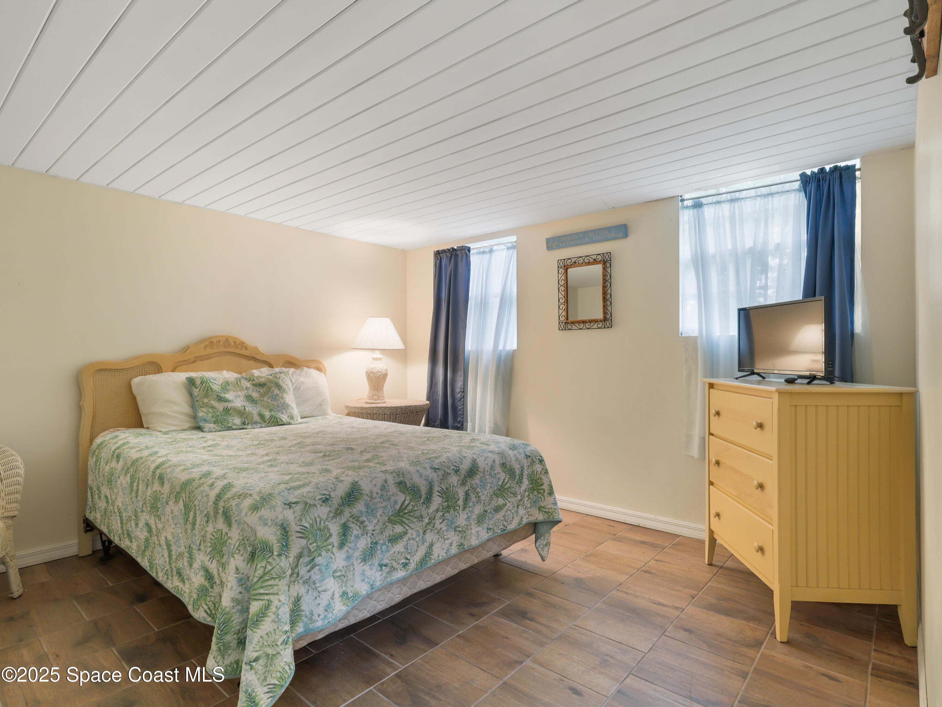 585 Canaveral Groves Boulevard Cocoa, FL 32926 - Photo 5 of 49 a bedroom with a bed and a flat tv screen on dresser