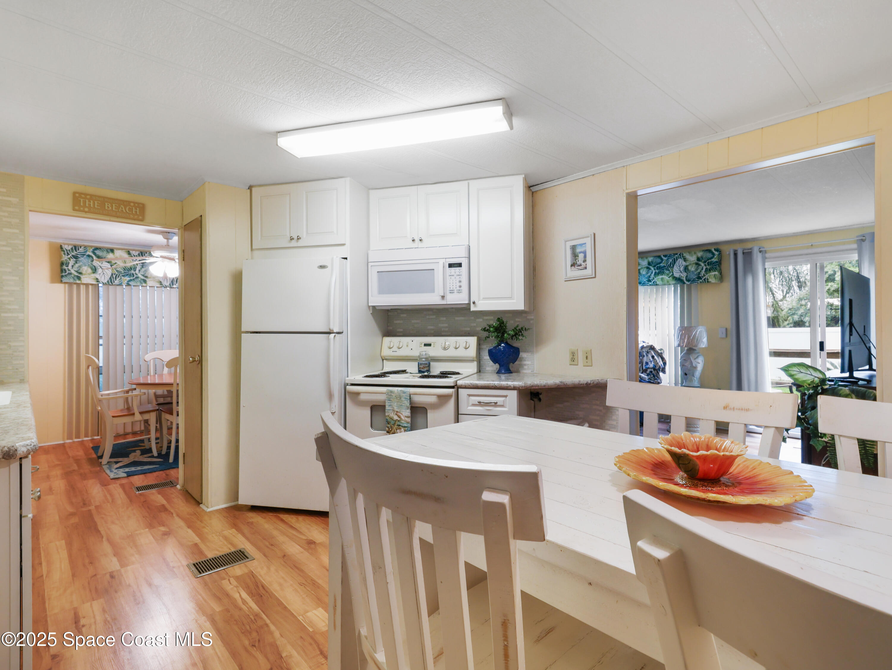 585 Canaveral Groves Boulevard Cocoa, FL 32926 - Photo 8 of 49 a large kitchen with stainless steel appliances a refrigerator a stove a sink a dining table and chairs