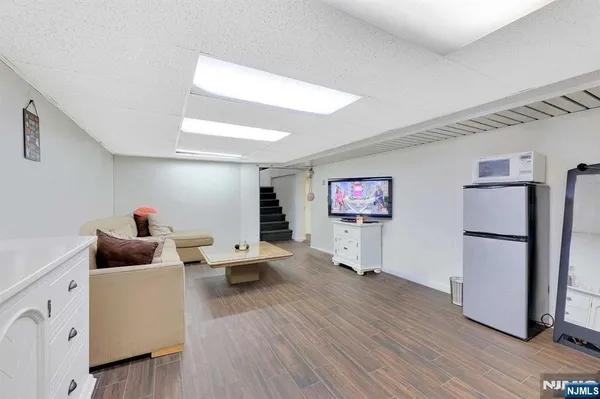 a living room with furniture and a refrigerator