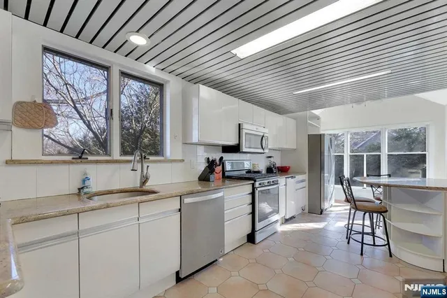 a kitchen with appliances a sink and cabinets