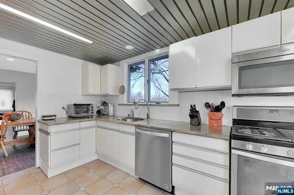 a kitchen with appliances a sink and cabinets