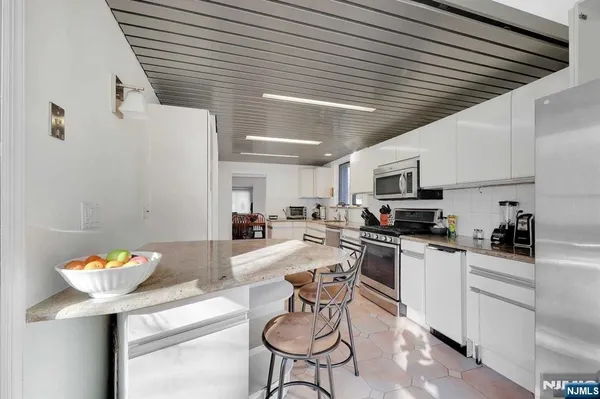 a kitchen with stainless steel appliances kitchen island granite countertop a sink and cabinets