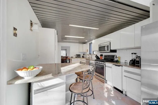 a kitchen with stainless steel appliances kitchen island granite countertop a sink and cabinets