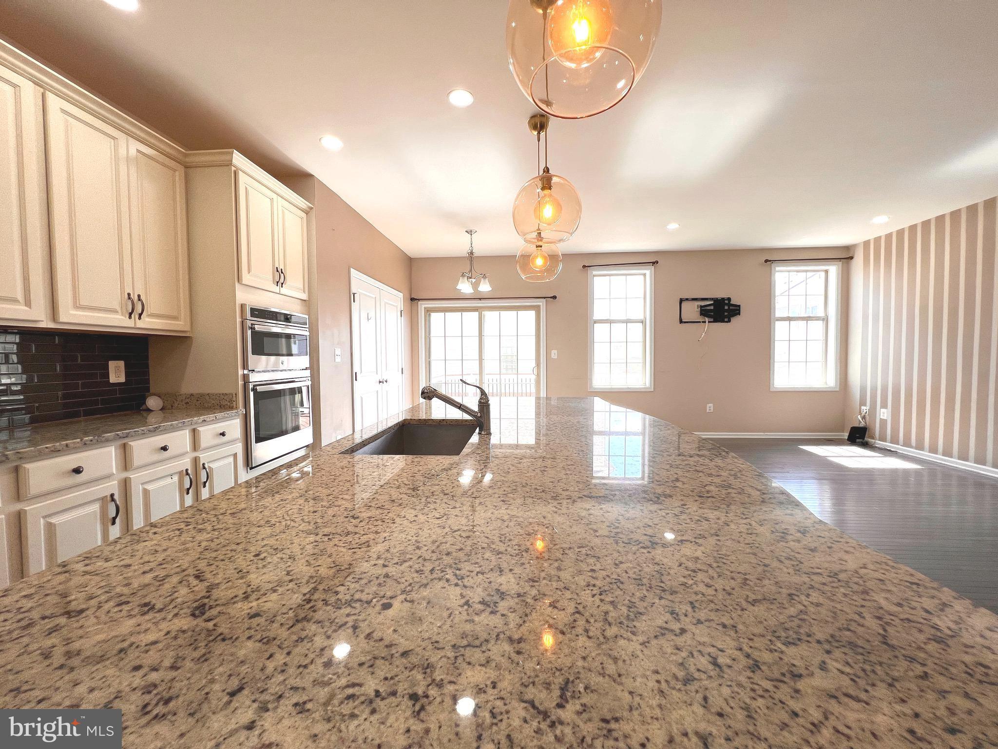 23480 Logans Ridge Terrace Ashburn, VA 20148 - Photo 19 of 66 a view of a kitchen with granite countertop a stove and a sink