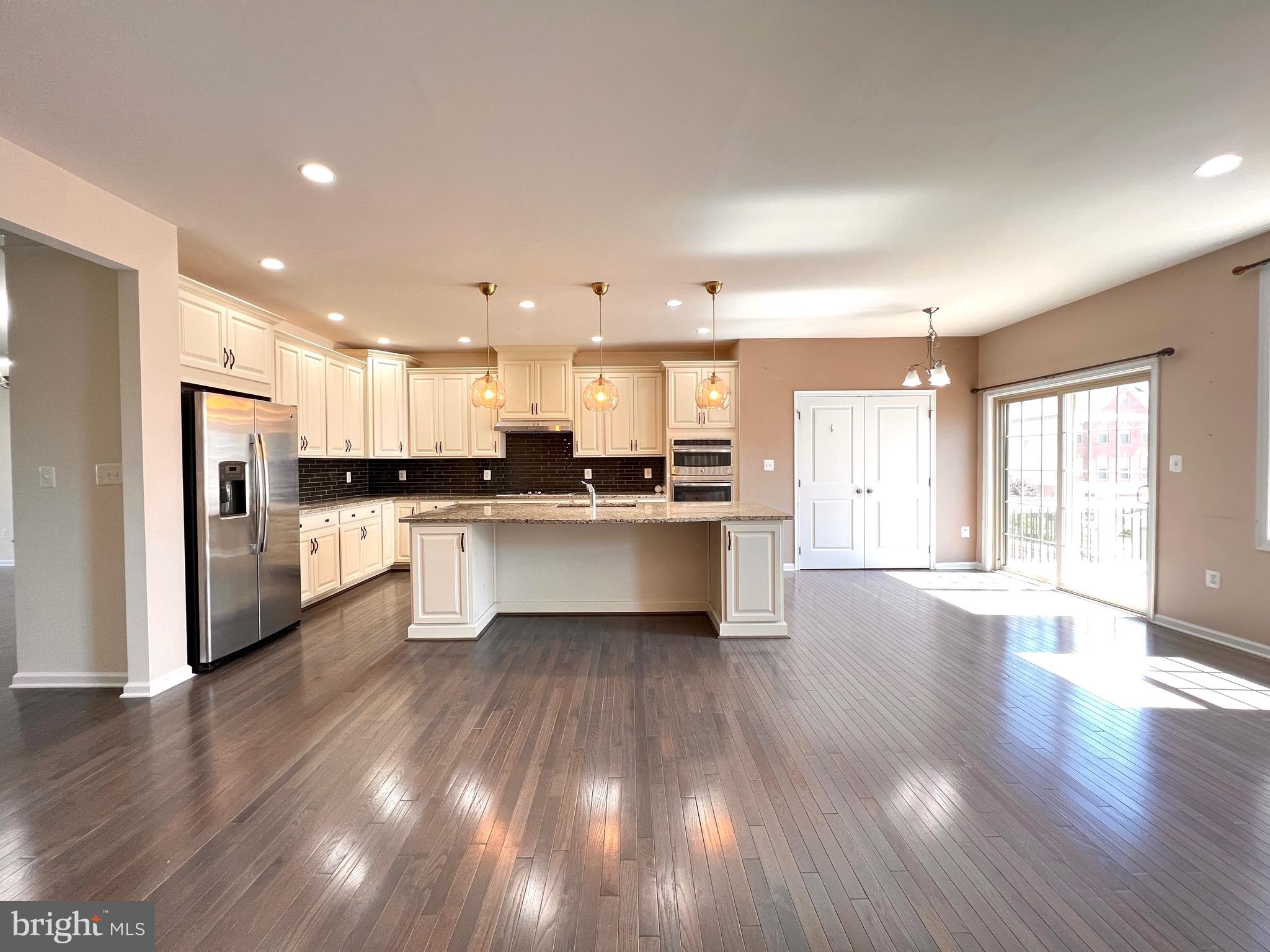 23480 Logans Ridge Terrace Ashburn, VA 20148 - Photo 21 of 66 a large kitchen with a center island wooden floor stainless steel appliances and a window