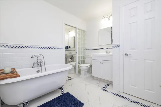 a bathroom with a tub sink and mirror
