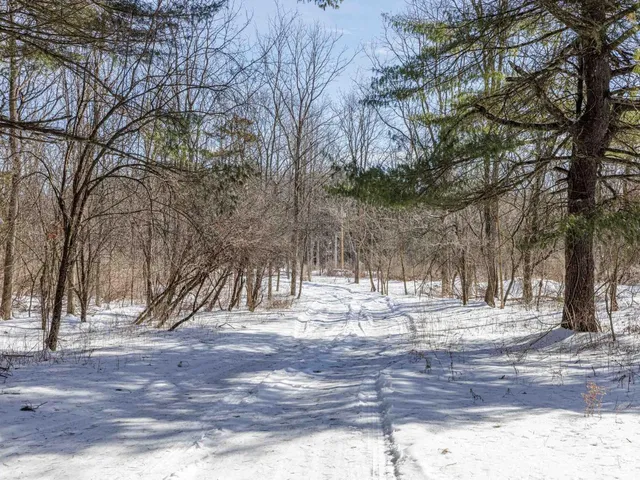 a large living room with stainless steel appliances granite countertop a couch a dining table and chairs with wooden floor