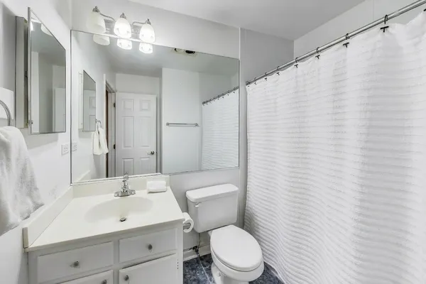 a bathroom with a toilet a sink and a mirror