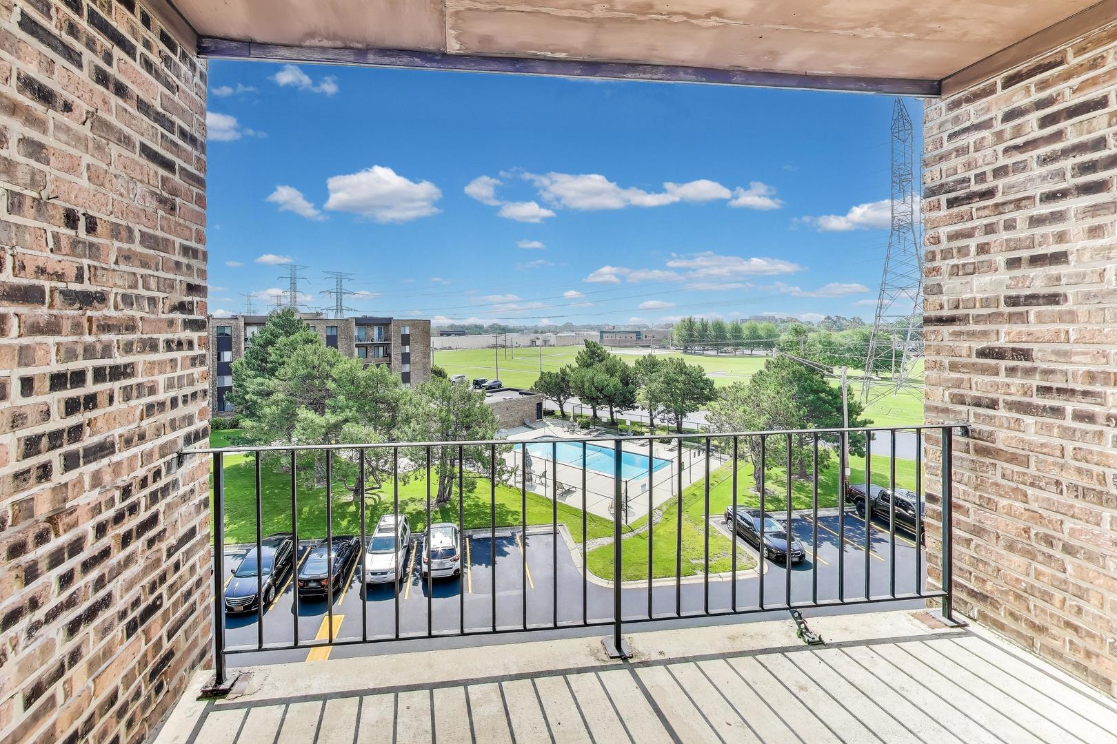 701 West Huntington Commons Road, Unit 418 Mount Prospect, IL 60056 - Photo 3 of 10 a view of a balcony with lake view and a floor to ceiling window