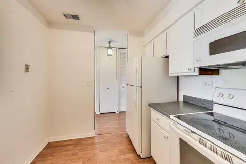 a kitchen with granite countertop a sink stove and refrigerator