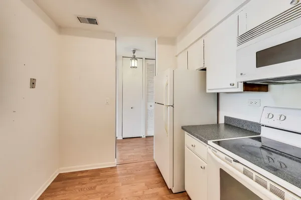 a kitchen with granite countertop a sink stove and refrigerator