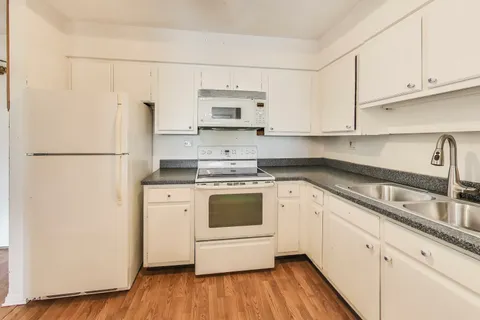a kitchen with stainless steel appliances white cabinets and a refrigerator