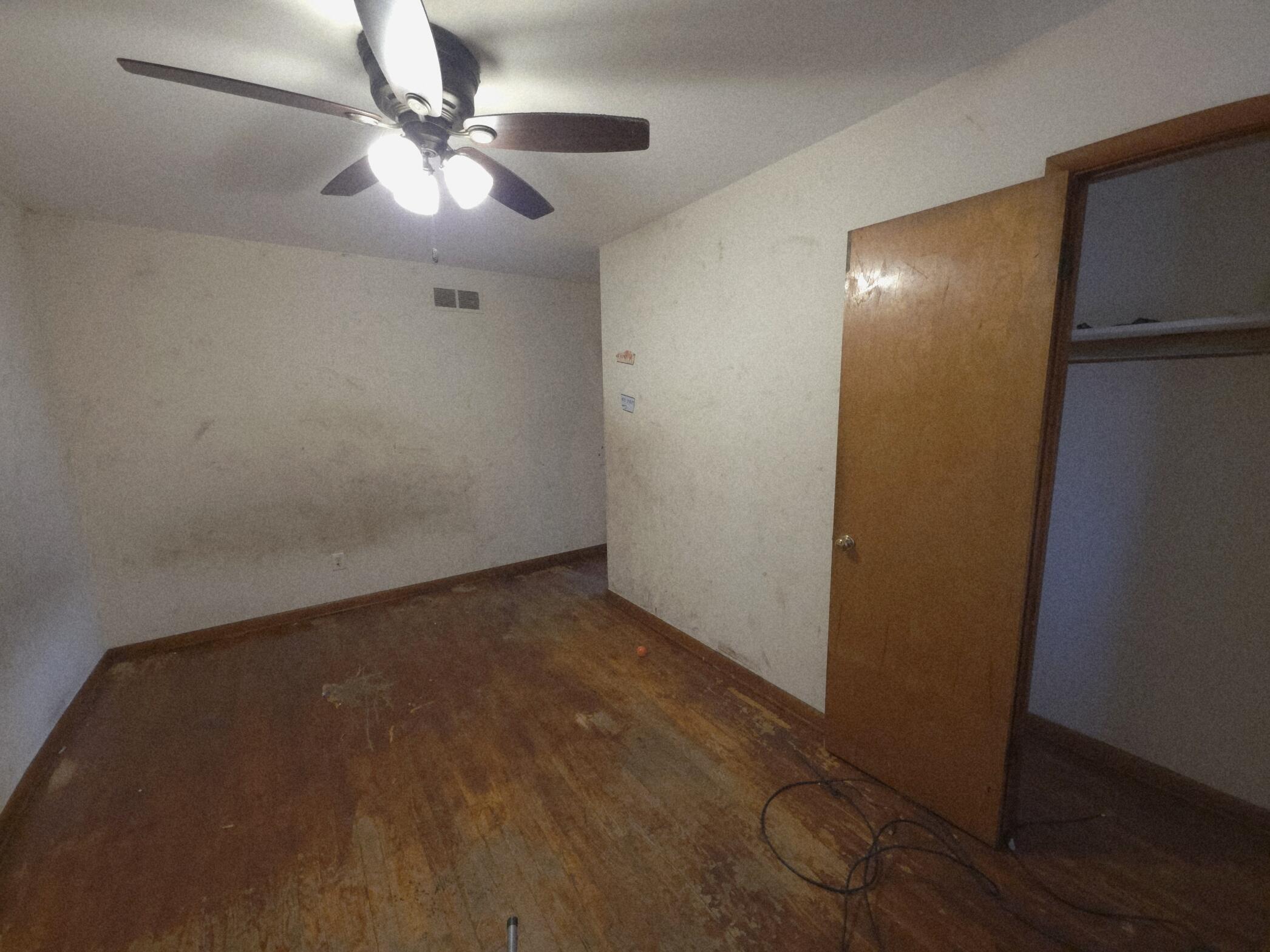 794 Porter Street Gary, IN 46406 - Photo 4 of 15 an empty room with a ceiling fan and wooden floor