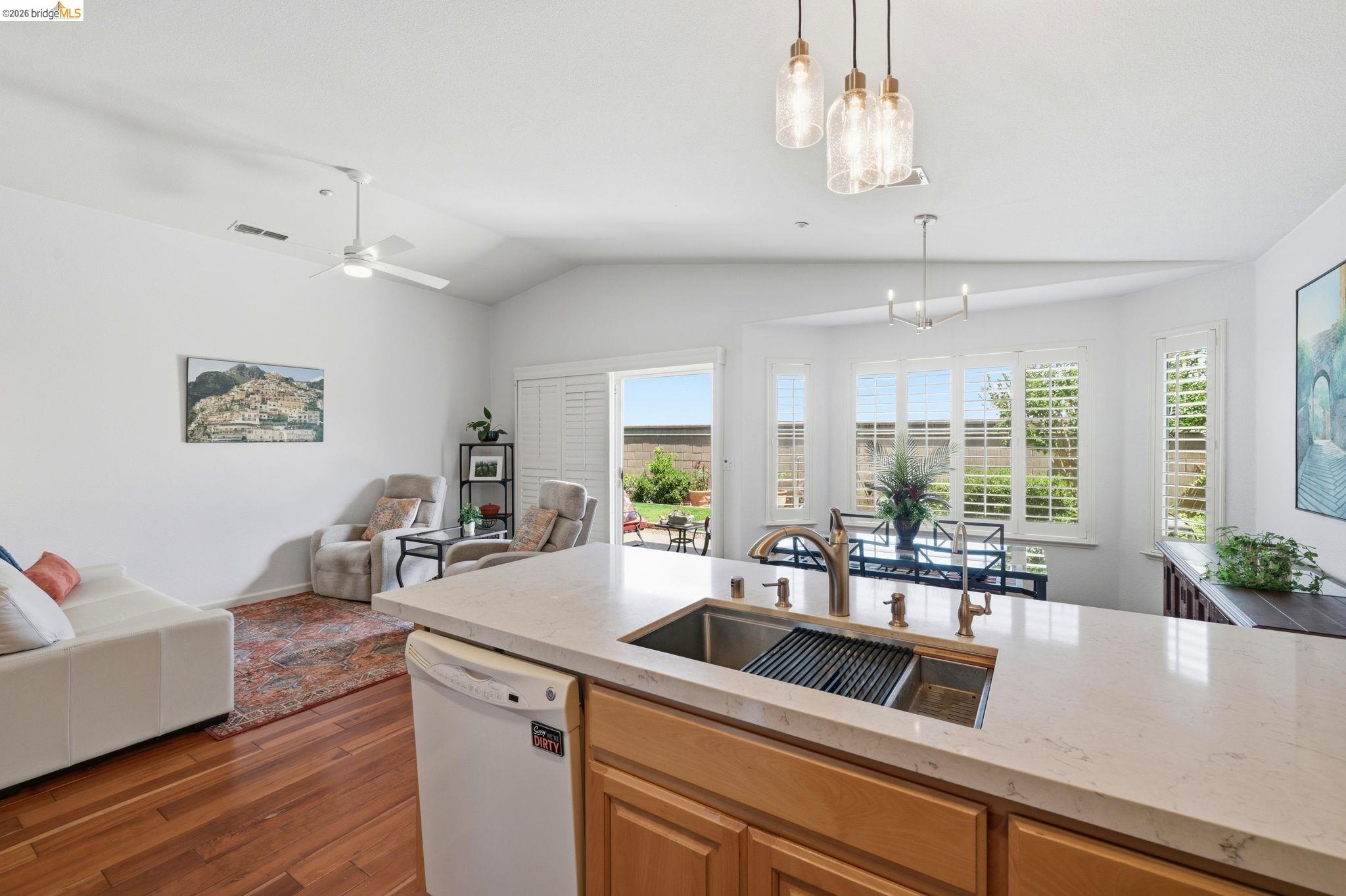 1024 Diamante Rio Vista, CA 94571 - Photo 9 of 27 Kitchen island featuring a double basin sink with a bronze faucet, stone countertop, and light wood cabinetry