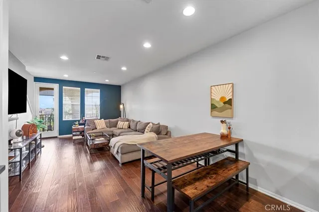 a living room with furniture and a wooden floor