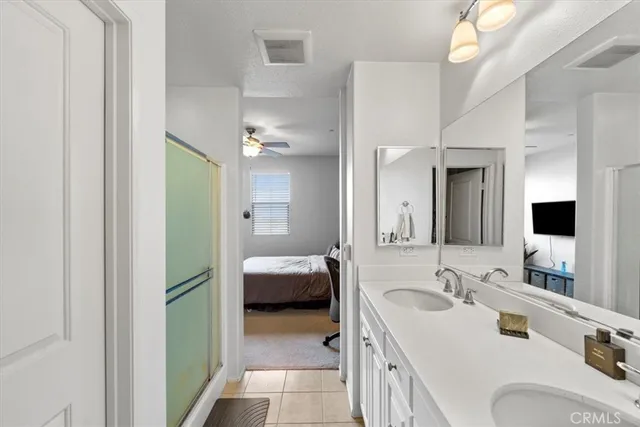 a en suite bathroom with a double vanity sink and a mirror