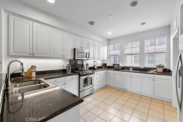 a kitchen with granite countertop white cabinets and white appliances