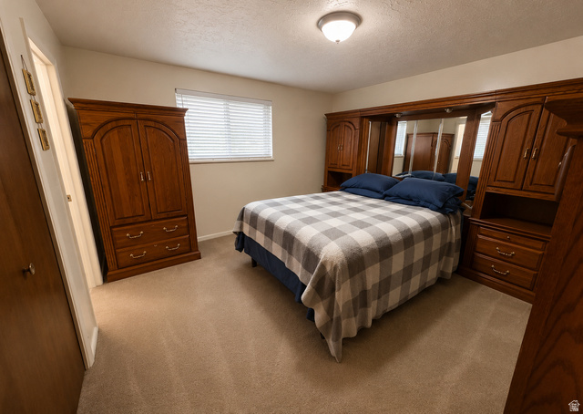 1020 Wilmar Place Centerville, UT 84014 - Photo 7 of 22 Bedroom featuring light beige carpeting, a window with horizontal blinds, and a built-in wooden wardrobe unit with mirrored panels