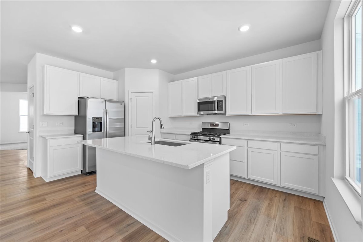 81 Sweetflag Circle Elgin, IL 60124 - Photo 12 of 51 a kitchen with white cabinets and stainless steel appliances