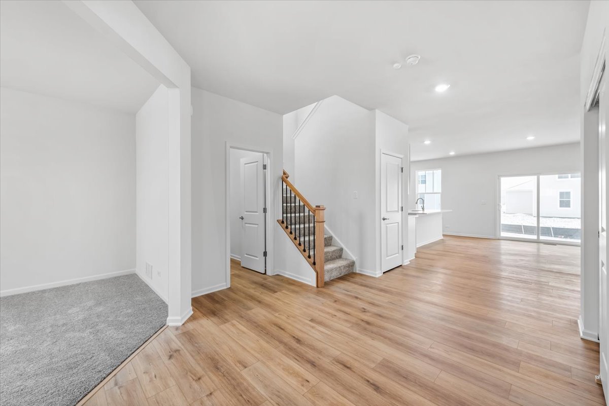 81 Sweetflag Circle Elgin, IL 60124 - Photo 8 of 51 a view of an empty room with wooden floor and stairs