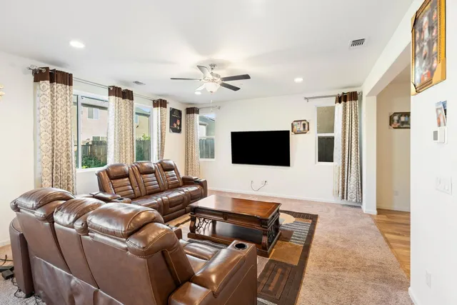 a living room with furniture kitchen view and a chandelier