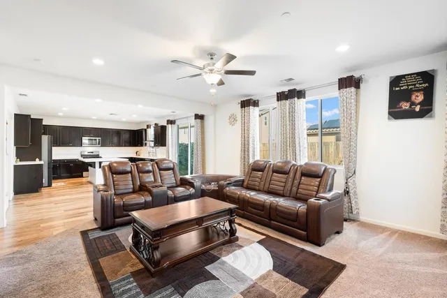 a large kitchen with stainless steel appliances kitchen island granite countertop a sink and a refrigerator